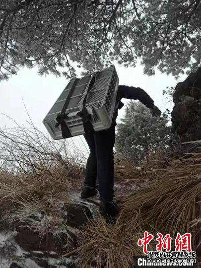 技术人员冒着风雪攀爬上陡坡 王政 摄 技术人员冒着风雪攀爬上陡坡 王政 摄